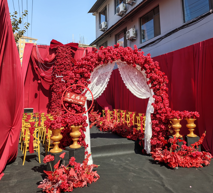 婚礼仪式未开始前舞台拱门上被挂上了婚庆公司的广告牌。（来源/受访者供图）