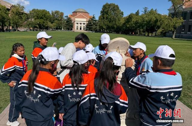 10月13日，来自西藏日喀则定日县的青少年走进清华大学，图为学生们在大礼堂前观看日晷。中新网记者 黄欣欣 摄