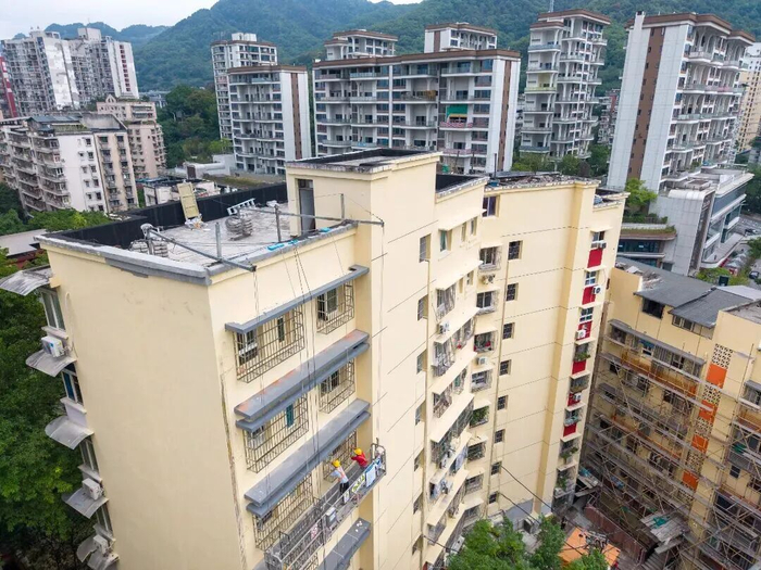 工人正在进行房屋外立面作业。图源：南岸发布