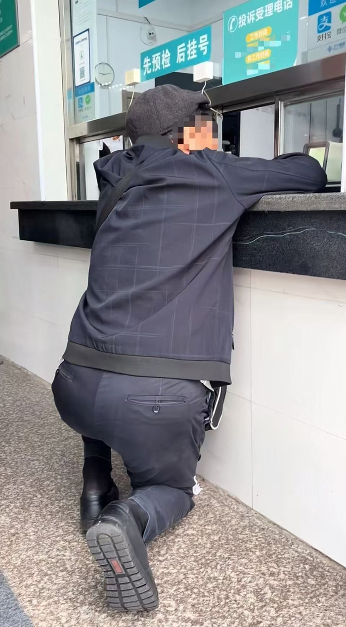 网友拍摄的视频画面显示患者半跪着与窗口内工作人员沟通。网络图
