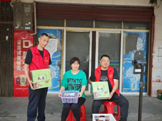 图为周春兰和志愿者线上推销板栗