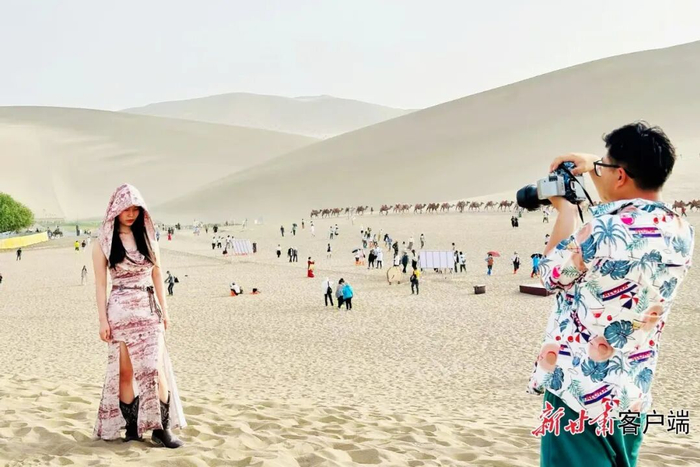       游客在鸣沙山月牙泉景区拍照打卡。