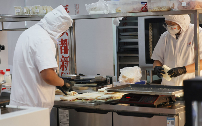 面包店工作人员正在制作早餐三明治。新京报记者 王贵彬 摄