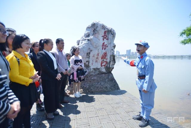 少年讲解员在于都长征渡口石碑前为参观者讲述长征历史（央广网见习记者闵楠思 摄）