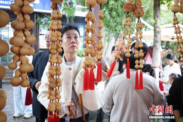 10月17日，山东省聊城市东昌府区，顾客在选购葫芦挂件。 中新社记者 周艺伟 摄
