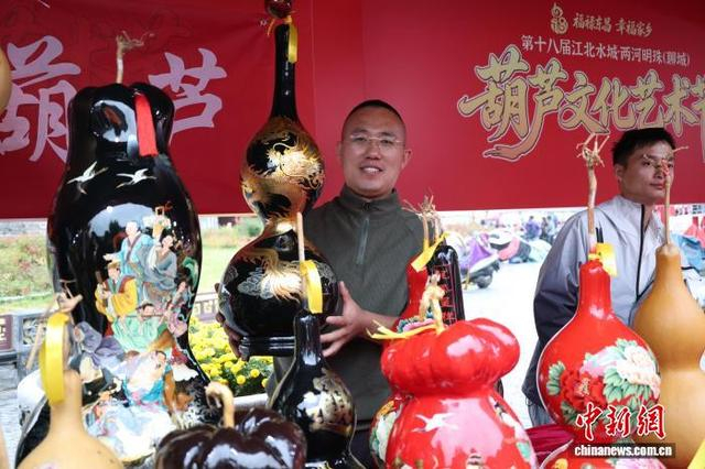 10月17日，山东省聊城市东昌府区，摊主展示“漆画葫芦”。 中新社记者 周艺伟 摄