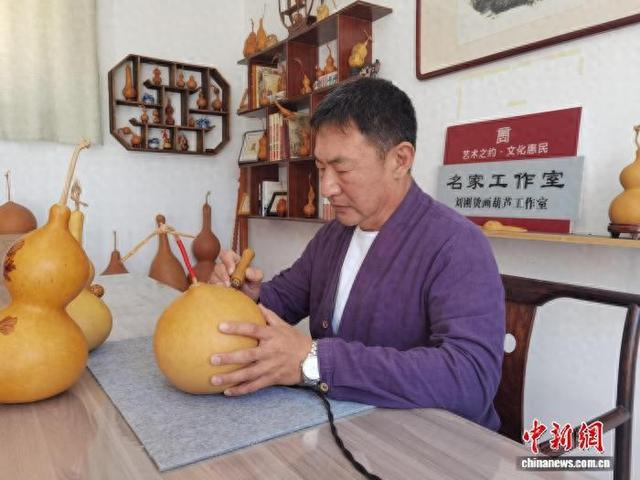 10月12日，刘刚在创作烫画葫芦。徐文云 摄