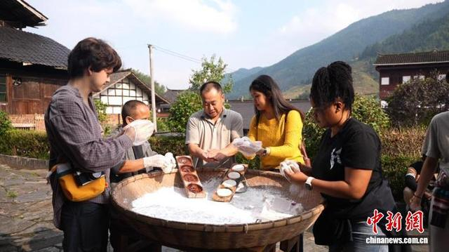 留学生们跟着村民学习打糍粑。曾湘涛 摄