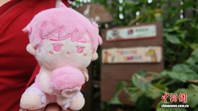 游客带着“周同学”玩偶，与认养牌合影。张传明 摄