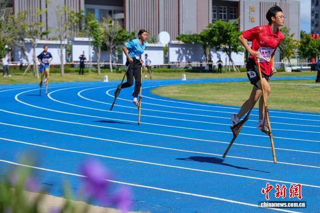 图为参加高脚竞速女子200米预赛的选手在比赛中。中新社记者 骆云飞 摄