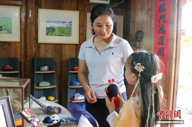 赤溪村内的民族文创集市，游客驻足挑选文创小品。王婷婷 摄