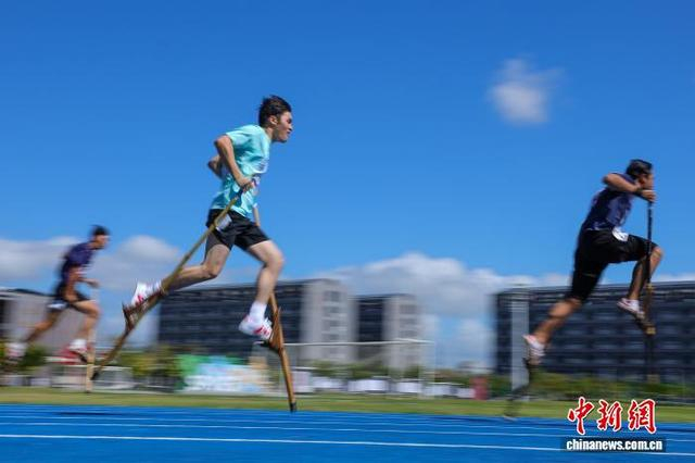 图为参加高脚竞速男子200米预赛的选手在比赛中。中新社记者 骆云飞 摄