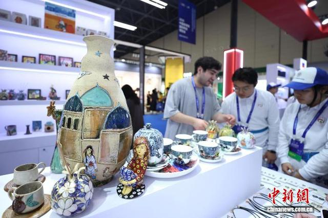 图为瓷博会“上合之窗”展区，塔吉克斯坦参展商介绍自己国家的陶瓷艺术品。中新社记者 刘占昆 摄