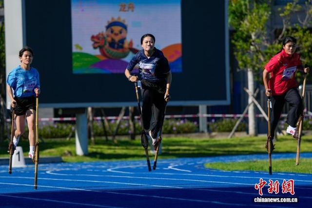 图为参加高脚竞速女子100米决赛的选手在比赛中。中新社记者 骆云飞 摄
