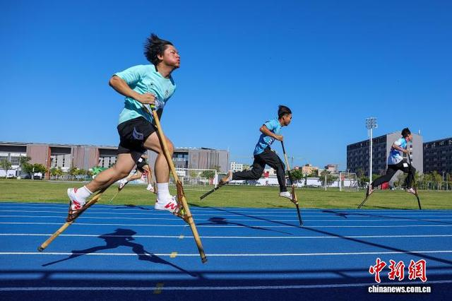 图为参加高脚竞速男子100米决赛的选手在比赛中。中新社记者 骆云飞 摄