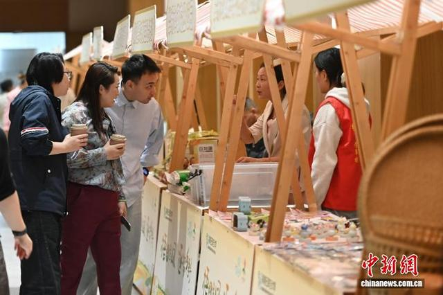 10月18日，游客在犁桥村一处市集上挑选文创产品。中新社记者 张强 摄