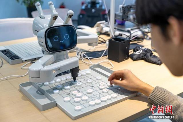 图为智能对弈机器人“元萝卜”和市民下象棋。金奇 摄