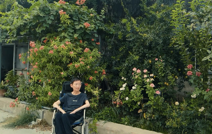 2022年，刘文燕坐在轮椅上看花散心。受访者供图