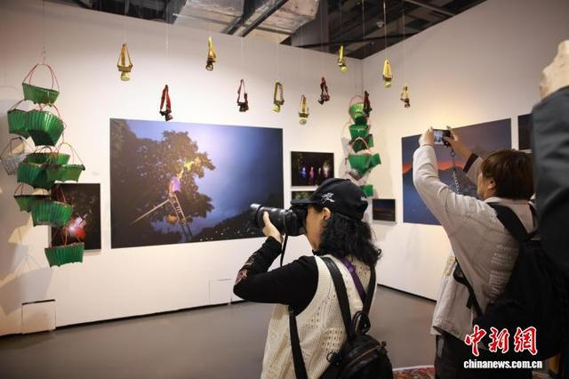 10月24日，摄影爱好者参观展览《杨梅又红了》并拍照打卡。中新社记者 孙杨洋 摄