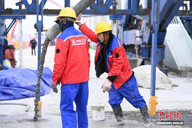 图为工人在现场进行混凝土浇筑作业。 戴文昌 摄