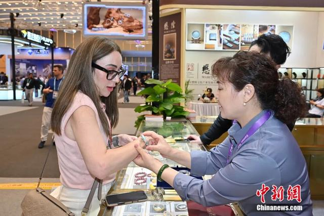 图为境外采购商在时尚饰品展区试戴手镯。中新社记者 陈楚红 摄