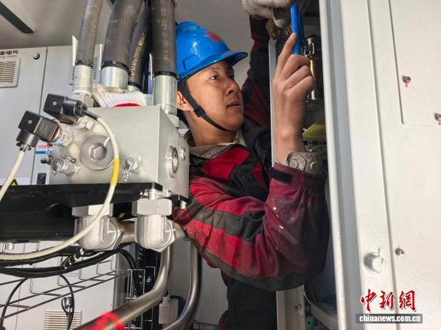 图为工作人员在风机机舱狭小空间内核对设备参数。刘伟 摄