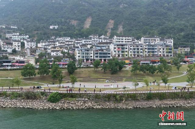 图为莲沱畔公园临江而建，白墙民居与青山碧水相映，成为 G348三峡公路上的休闲打卡点。闫志 摄 