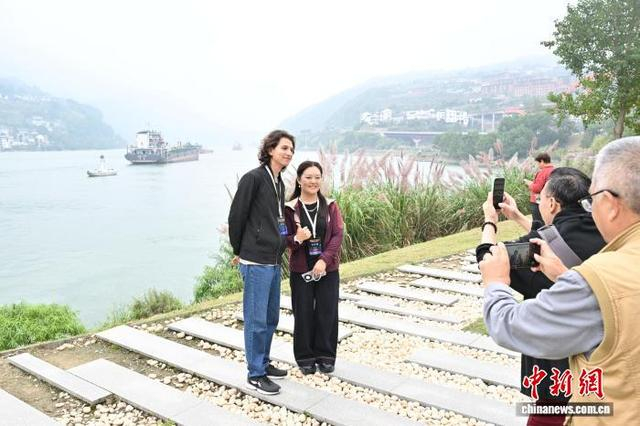 图为海外华文媒体代表在莲沱畔江边留影，欣赏峡江风光。田耀平 摄 