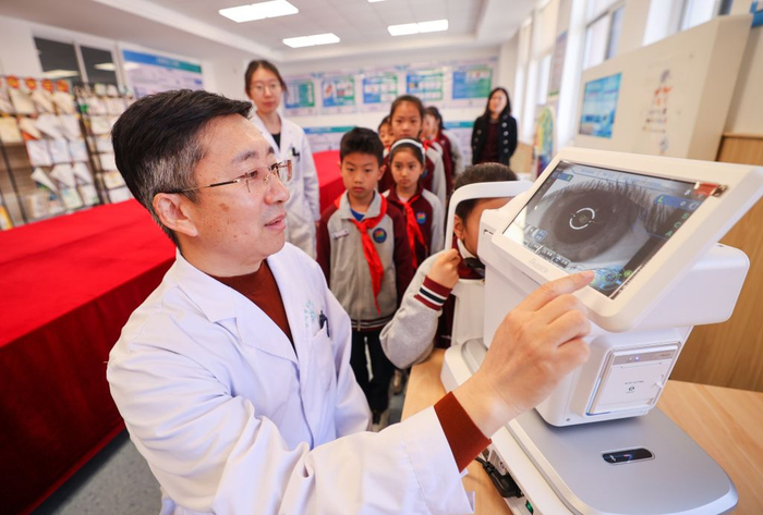 在山东省荣成市实验小学近视预防智慧平台，眼科医护人员使用电脑验光仪为学生开展专业视力检测。新华社发