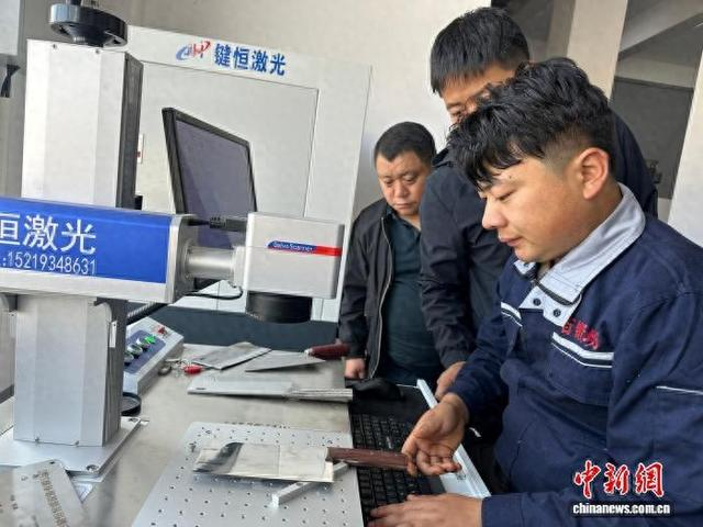 图为积石山县保安腰刀生产加工车间操作员校准设备。刘威 摄