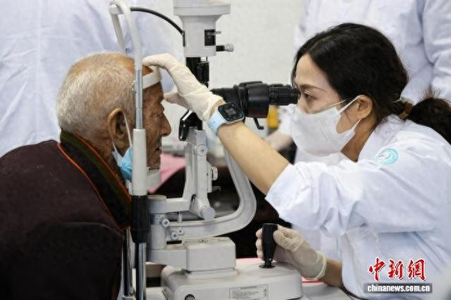 图为援藏眼科专家熊廷彦为老人进行眼病筛查。王颖 摄