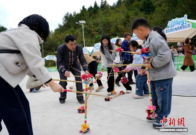 图为全国“村 BA” 总决赛期间配套 “村趣” 活动现场，游客体验土家族打莲湘民俗项目，感受乡土民俗乐趣。叶莉 摄