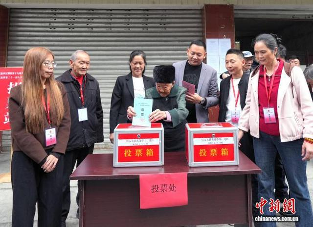 图为李青秀老人（左四）在投票。中新社记者 安源 摄 