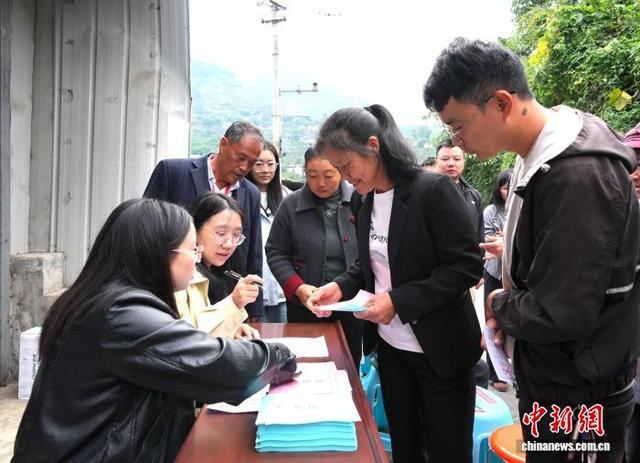 图为李青秀老人的儿媳妇徐明珍（右二）在领取选票。中新社记者 安源 摄 