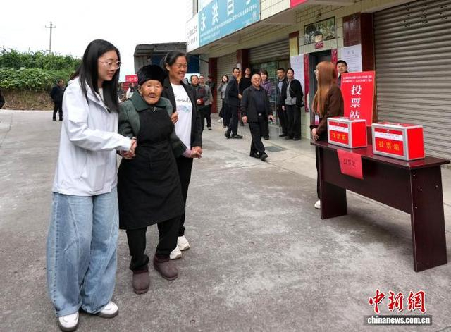 图为李青秀老人的曾孙女冯鑫垚（左一）及儿媳妇徐明珍和搀扶老人来到投票点。中新社记者 安源 摄 