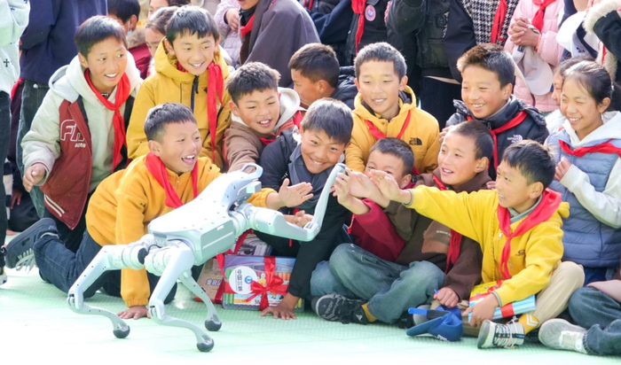 ▲ 孩子们激动地与机器狗握手互动 摄影：明媚