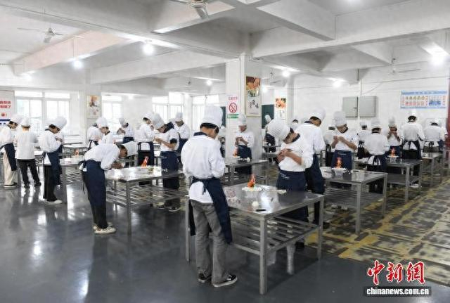图为重庆市开州区巨龙中等职业技术学校的实训教室里，学员们练习雕花技艺。中新网记者 周毅 摄