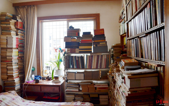  ↑刘国成家中卧室也满是藏书，床头柜书堆高过窗户上沿
