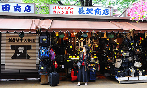 一名商贩在日本东京浅草寺外等待顾客。（新华社）