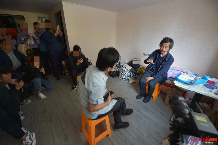 　▲2019年5月7日，上海市杨高南路地铁站出口，沈巍的粉丝和同学帮他在附近租了一间房栖身，他正接受红星新闻记者专访，期间众多粉丝开起直播。