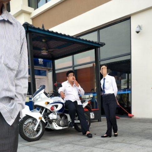  ↑邓大楣晕倒在地，裴某璟坐在警用摩托车上吸烟