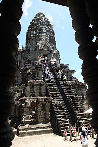 在柬埔寨暹粒省的吴哥寺，游客从最高层祭台上的木制楼梯向上攀爬。（新华社）