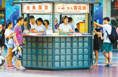 上海南京东路步行街，不少顾客在专卖“雪花膏”化妆品的小商铺挑选化妆品。 　　人民视觉