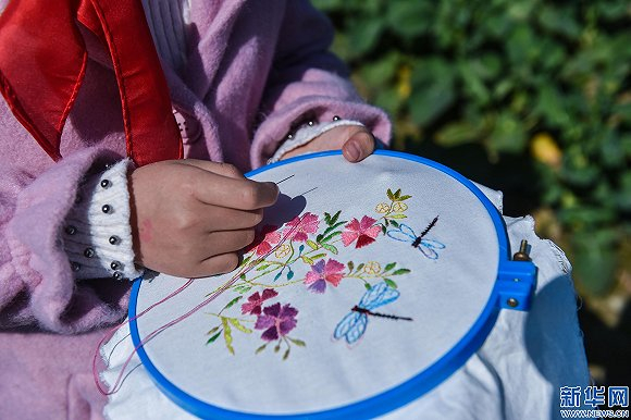 织里镇上如今仍保留刺绣的传统，孩子们从兴趣班开始学刺绣。图片来源：新华社