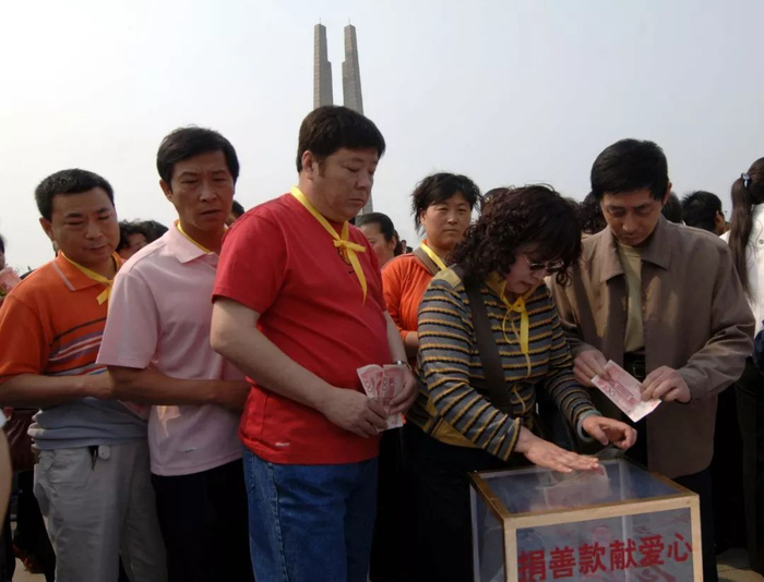 2008年5月20日，在唐山抗震纪念碑广场，从河北省各地赶来的唐山地震孤儿们正在捐款。当日，通过网络倡议、电话联系等方式，200多名唐山地震孤儿聚集到唐山抗震纪念碑广场，举行为四川汶川大地震孤儿献爱心的捐献活动。新华社记者巩志宏摄