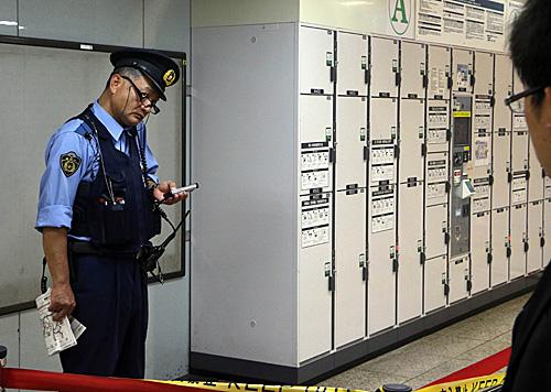 资料图:一名警察在日本铁路公司东京站内的寄存柜附近警戒。(新华社)