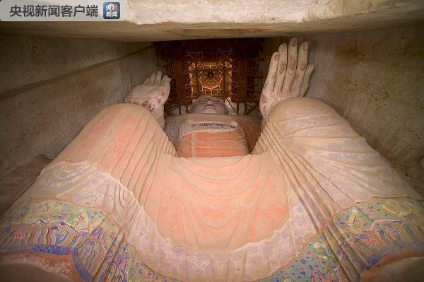 　　△第96窟内塑有莫高窟现存最大的一身倚坐佛像。它建造于延载二年（公元695年）。塑造的是未来佛弥勒佛，佛像高35.5米。这身造像为石胎泥塑，工匠先在崖壁上凿刻出佛像的大体轮廓，然后用草泥垒塑，再用麻泥细塑，最后敷彩而成。（敦煌研究院提供）