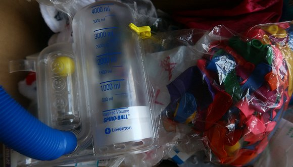 为了锻炼肺功能，傅月常常吹气球。摄影：黎文婕