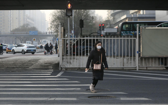 双井桥下十字路口，看到指示灯变红，过路女子小跑着走完斑马线。新京报记者 郑新洽 摄