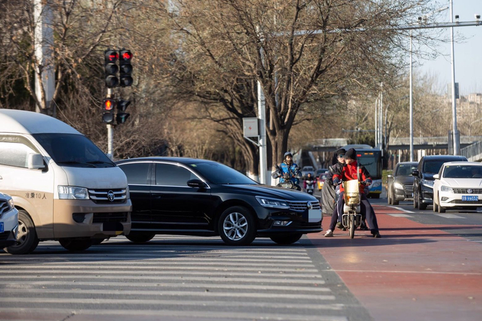 丰台区丰益桥（丰管路与西三环辅路交汇处），市民骑电动车在路中间等待。新京报记者 李凯祥 摄